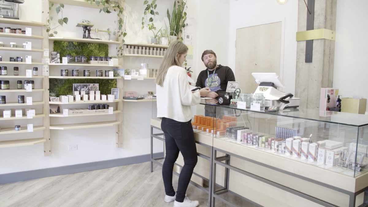 A customer and budtender talking at the register inside the Vapor Room dispensary