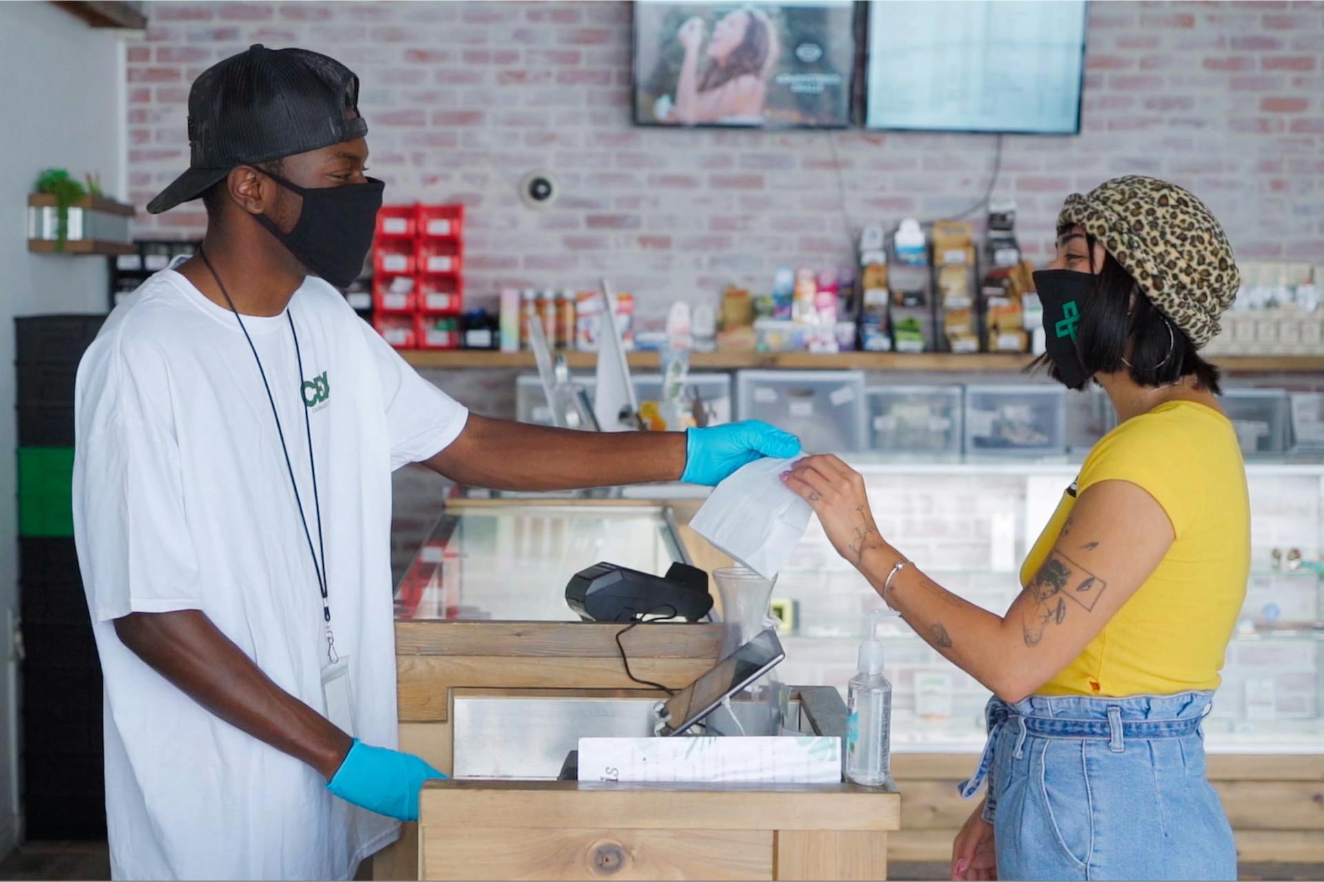 A budtender at The Green Cross hands off an order to a customer