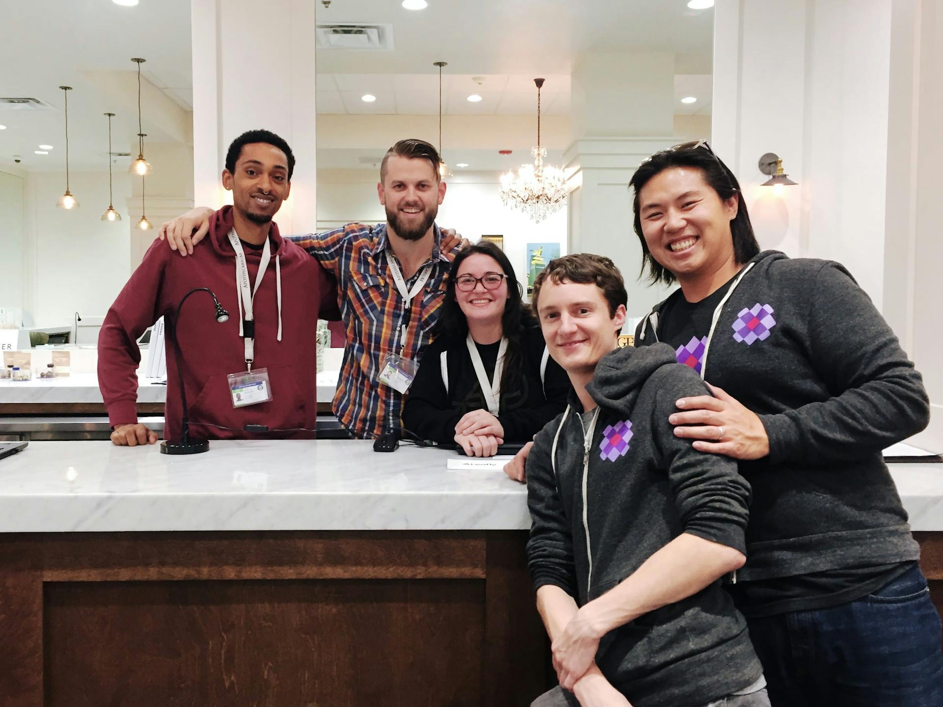 Meadow employees pose with dispensary employees at a marble counter