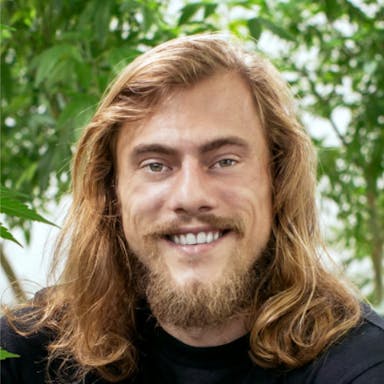 Steven Murray smiling among cannabis plants