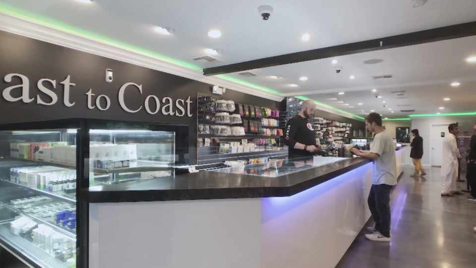 The counter at Coast to Coast, with a budtender and customer