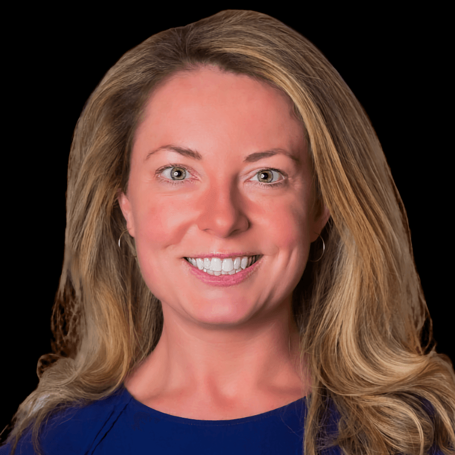 A smiling white woman with luxurious blonde hair and hazel eyes, wearing a blue shirt.